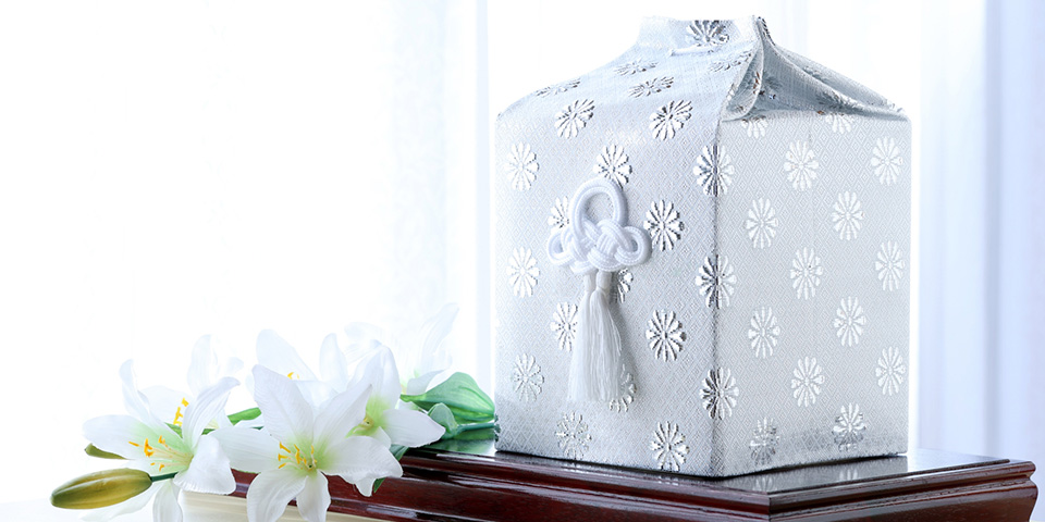 セレモニーハート西大島ホールが江東区で提供する白い仏壇用骨箱とユリの飾りの安らかな遺骨安置イメージ